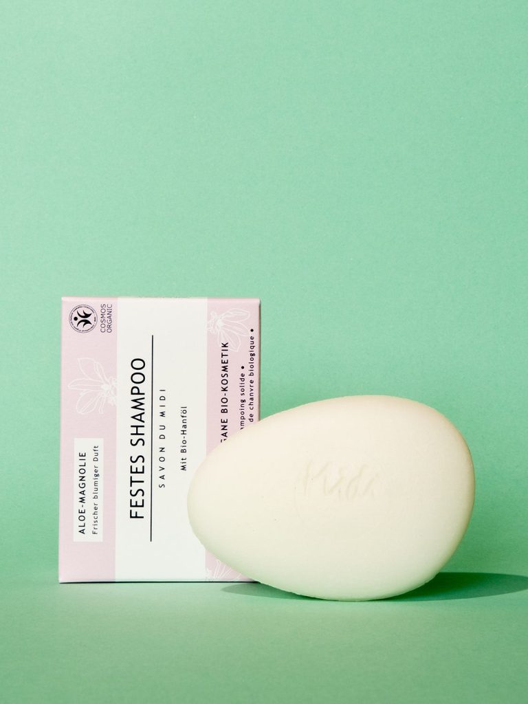 Aufsicht auf einen Festen Conditioner und ein Shampoo von Savon du Midi, mit zugehöriger Verpackung.